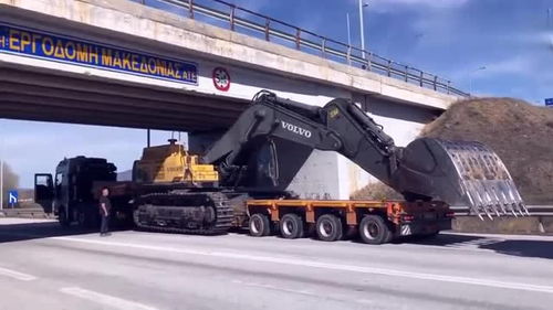 半掛車運輸挖掘機遇限高橋，老司機巧妙應對顯功力